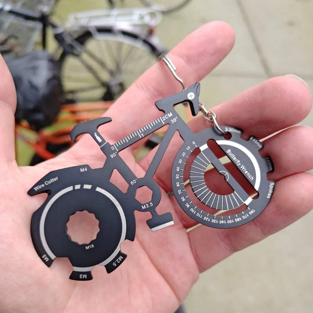 Bicycle keychain multitool held in hand at a bike park