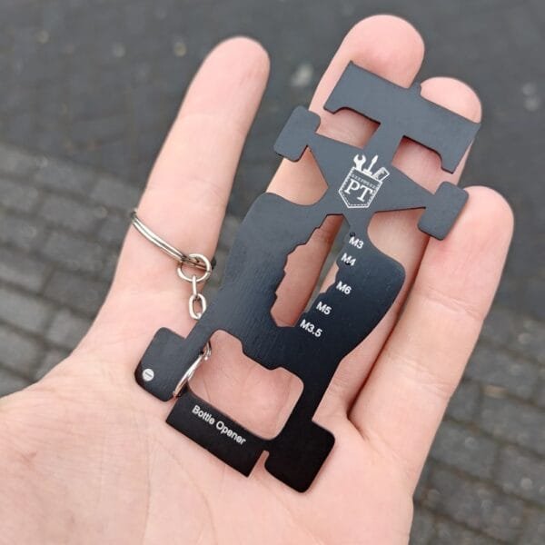 Race Car Multitool keychain held in hand showing off backside of form and features