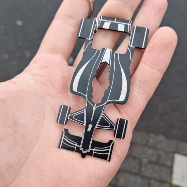 Race Car Multitool keychain held in hand showing off front of form and features