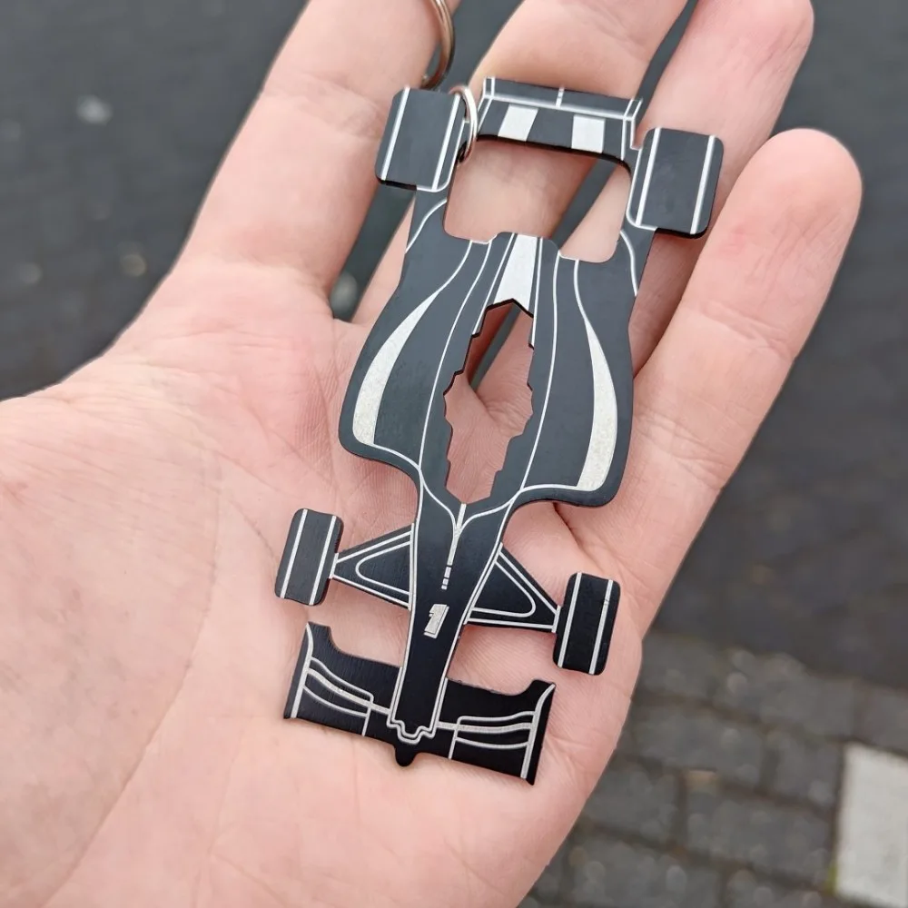Race Car Multitool keychain held in hand showing off front of form and features