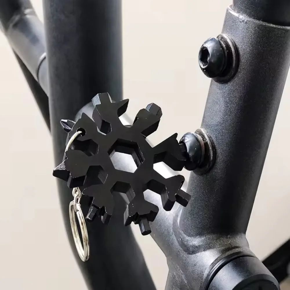 Black Snowflake Multitool Keychain used to tighten a bolt