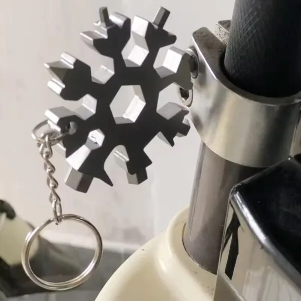 Snowflake Multitool Keychain used to tighten a screw on a bicycle