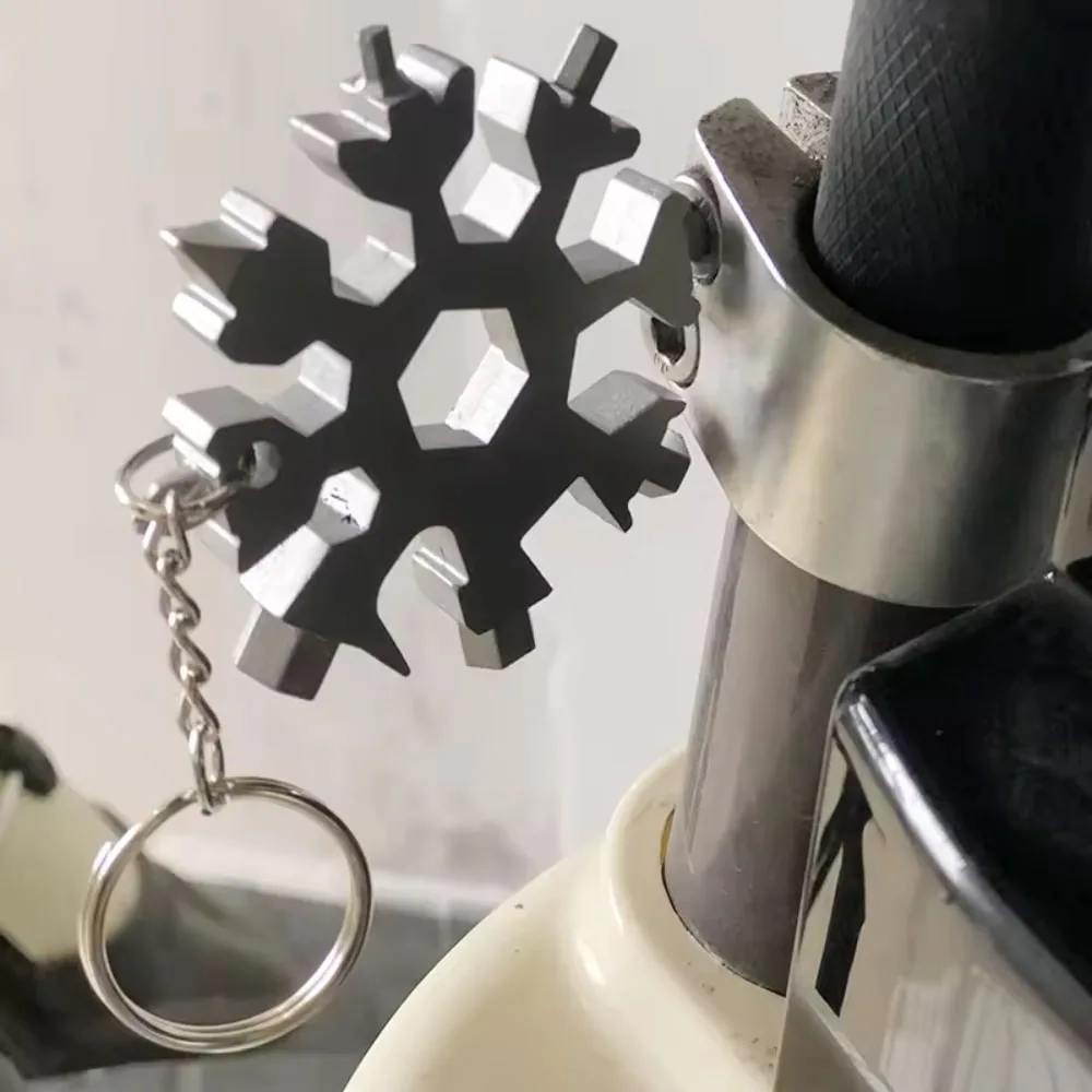 Snowflake Multitool Keychain used to tighten a screw on a bicycle