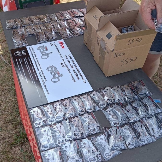 Lots of Honda C50 and Honda SS50 Pocket Tools laying on a table waiting to be given away to the event visitors